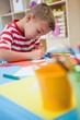 © WavebreakMediaMicro - Cute little boy cutting paper shapes in classroom