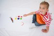 © WavebreakMediaMicro - Cute little boy painting on floor in classroom