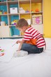 © WavebreakMediaMicro - Cute little boy painting on floor in classroom