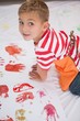 © WavebreakMediaMicro - Cute little boy painting on floor in classroom