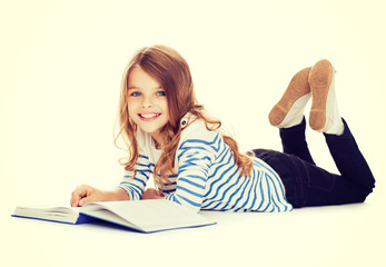 Wall Mural - smiling little student girl lying on the floor