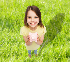 Wall Mural - beautiful little girl with piggy bank