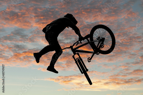 Plakat na papierze fotorealistycznym Sylwetka bmx sport jeździec w akcji z tłem scenerii