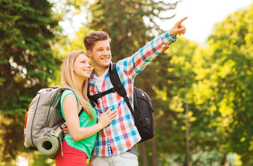 smiling couple with backpacks in nature