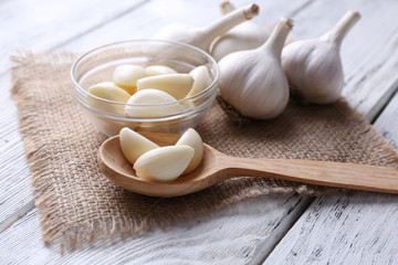 Poster - Fresh sliced garlic in glass bowl on wooden background