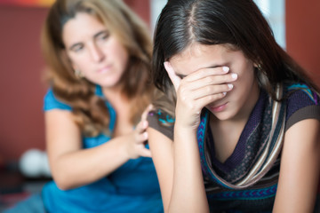 Mother comforts her teen daughter at home