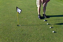 Golfer Practicing Putting With Several Golf Balls