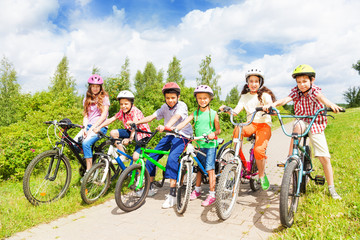 Row of kids diversity in helmets and bikes