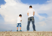 Father And Son Standing On A Stone Platform And Pee Together