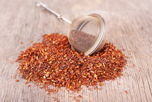 Dried Rooibos Tea In Tea-strainer On Wooden Table