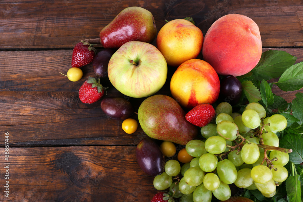 Different berries and fruits on wooden table close-up