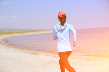 Wall Mural - Runner athlete running on stone beach of qinghai lake