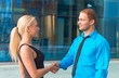 © M-Production - Business meeting. Man and woman shaking hands outdoors.