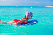 © travnikovstudio - Little adorable girl on a surfboard in the turquoise sea