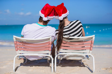 Wall Mural - Young couple in Santa hats enjoy beach vacation