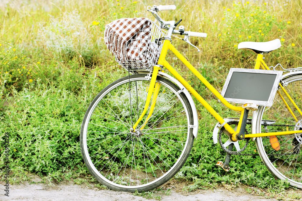 Bicycle with chalkboard in meadow during sunset
