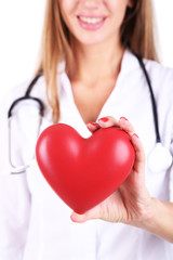 Poster - Young beautiful doctor holding red heart, close-up