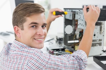 Young technician working on broken computer