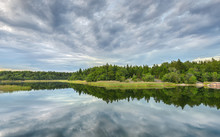 Forest And Cloud Reflections In Lake