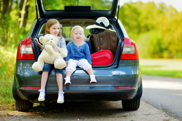 Two little sisters going to a car vacation