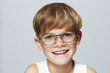 Portrait of young boy wearing glasses, studio.