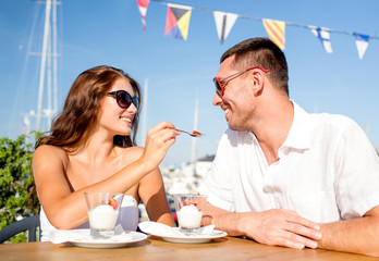 smiling couple eating dessert at cafe