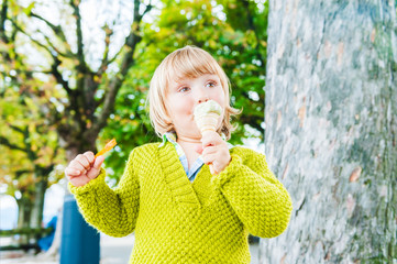 Wall Mural - Portrait of a cute toddler boy eating pistachio ice cream