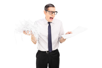 Wall Mural - Shocked businessman holding shredded documents