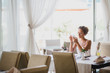 © polinaloves - Young woman sitting in a cafe using her phone
