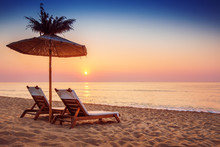 Vivid Sunrise On A Beautiful Sandy Beach With Sunshade