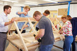 © Monkey Business - Teacher Helping College Students Studying Carpentry