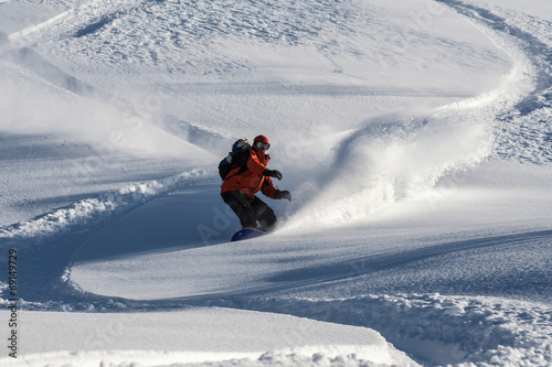 Board z aluminiowym obramowaniem Snowboardzista schodzi po śniegu w proszku.