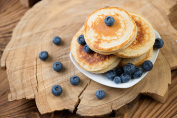 Wall Mural - Pancakes with fresh blueberries over rustic wooden background