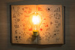 © jannoon028 - vintage book of business graph and light bulb on wood table
