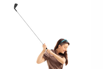 Poster - Profile shot of a woman swinging a golf club