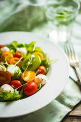 Canvas Print - Salad with arugula,tomatoes and mozarella on wooden background