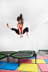 Wall Mural - Jumping young woman on a trampoline