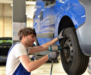 Wall Mural - Reifenwechsel in einer KFZ Werkstatt // Tire change by mechanic