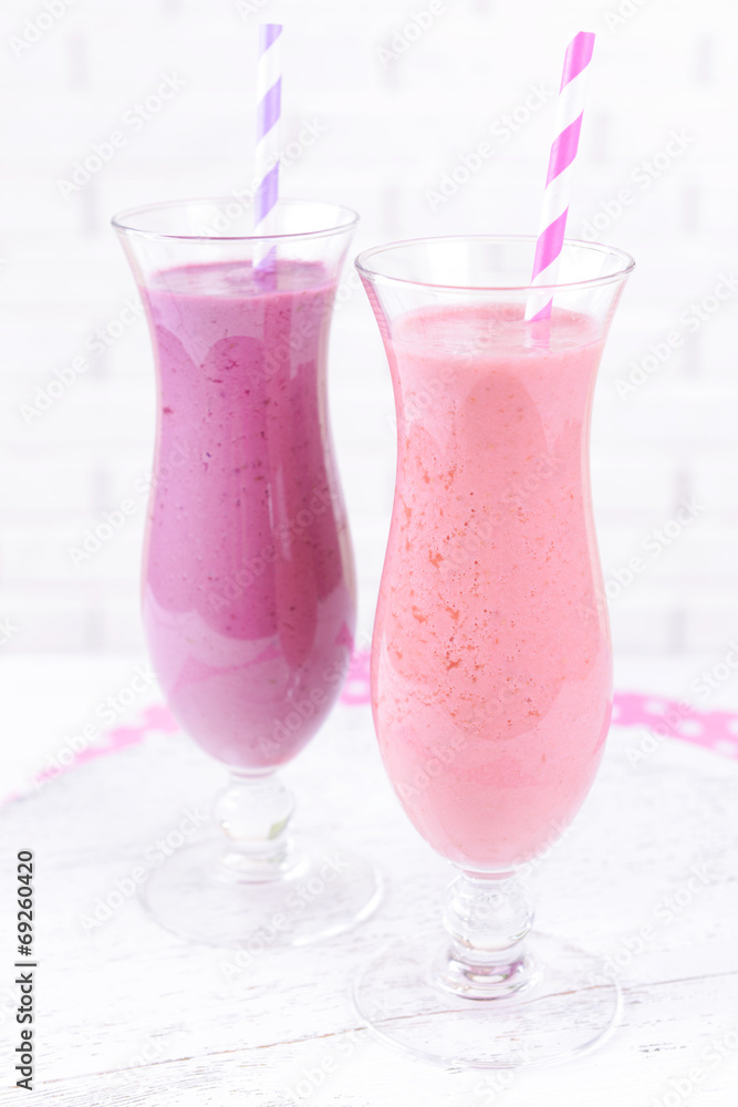 Delicious berry cocktails on table on brick wall background