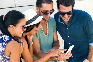 Portrait of group of friends having fun with smartphones.