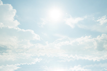 blue sky with clouds and sun reflection in water.
