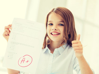 Wall Mural - smiling little student girl with test and A grade