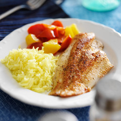 Sticker - fried tilapia filet with yellow rice and colorful bell peppers