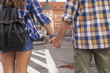 © De Visu - Rear view of a couple  tourists holding hands.