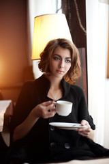 Young beautiful woman in a cafe. Modern trendy blondy girl in re