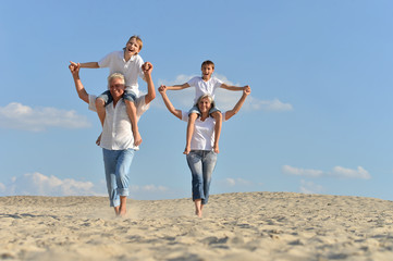 Canvas Print - Boys with grandparents sitting on sand