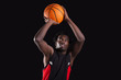Basketball player dunking on black background