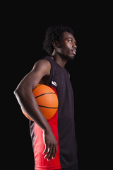 Wall Mural - Basketball player standing with a basket ball on black backgroun