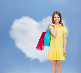 Canvas Print - smiling little girl in dress with shopping bags