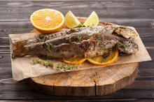 Baked Trout Fish With Orange And Herbs On Wooden Background